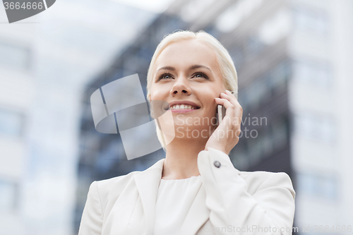 Image of smiling businesswoman with smartphone outdoors