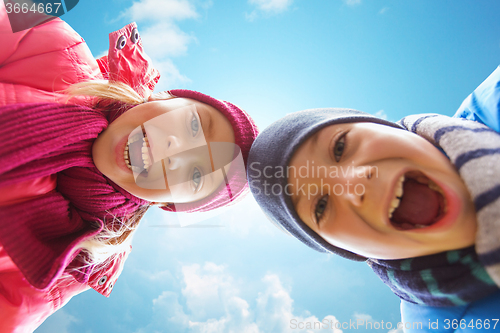 Image of happy little boy and girl faces over blue sky