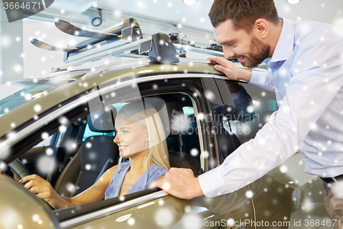 Image of happy couple buying car in auto show or salon