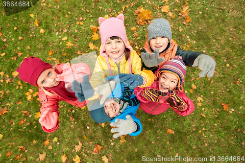 Image of happy children waving hands in autumn park