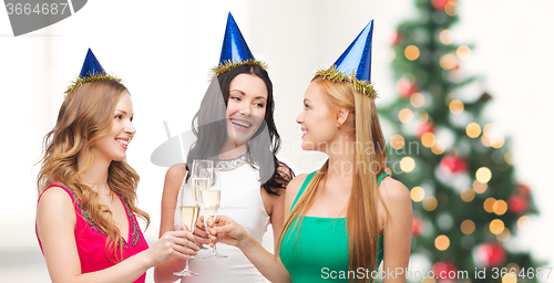 Image of three women wearing hats with champagne glasses