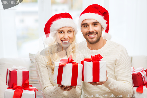 Image of happy couple at home with christmas gift boxes