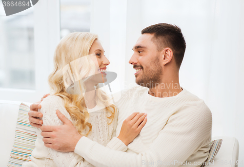 Image of happy couple hugging on sofa at home