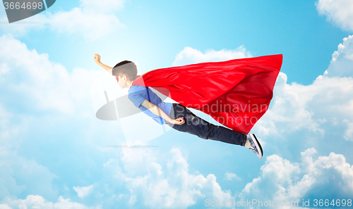 Image of boy in red superhero cape and mask flying on air