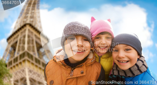 Image of group of happy children hugging over eiffel tower