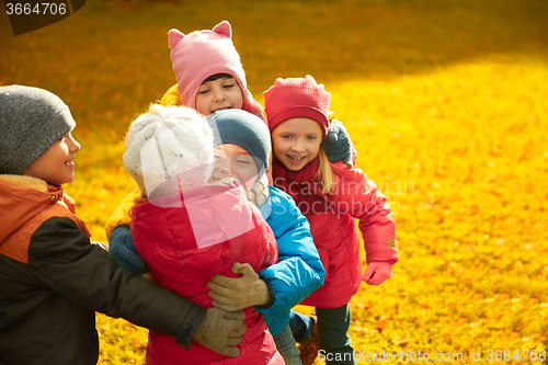 Image of group of happy children hugging in autumn park