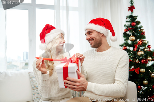 Image of happy couple at home with christmas gift box