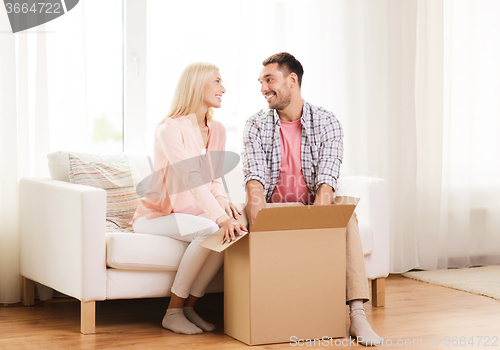 Image of happy couple with cardboard box or parcel at home