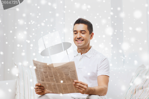 Image of happy man reading newspaper at home