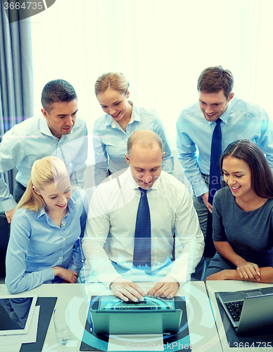 Image of smiling business people with laptop in office