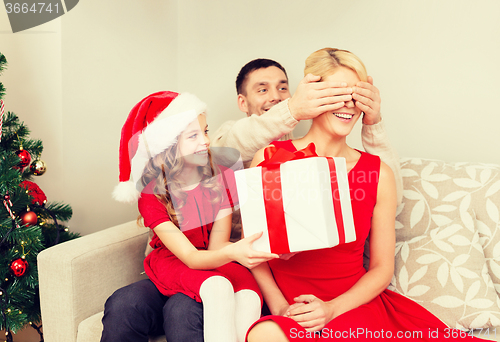 Image of father and daughter surprise mother with gift box