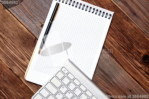 Image of Computer keyboard, notebook and pen