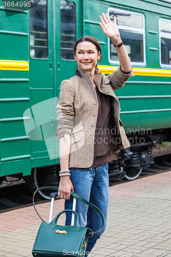 Image of beautiful middle-aged woman waving good-bye