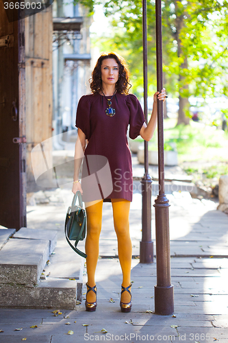 Image of beautiful middle-aged woman in a burgundy dress