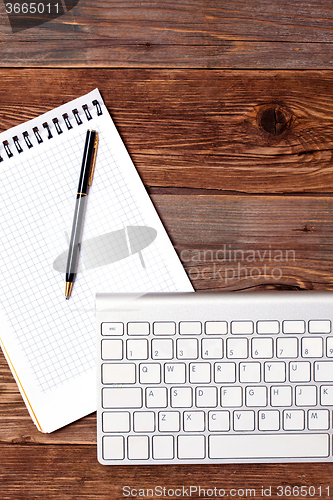 Image of notebook pen and computer keyboard