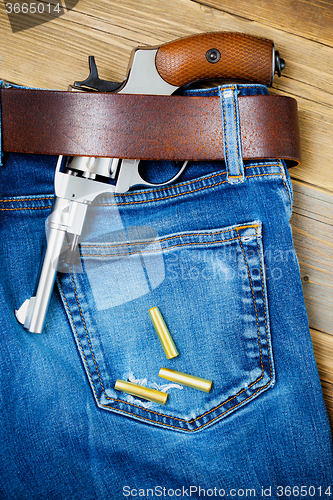 Image of revolver under a leather belt
