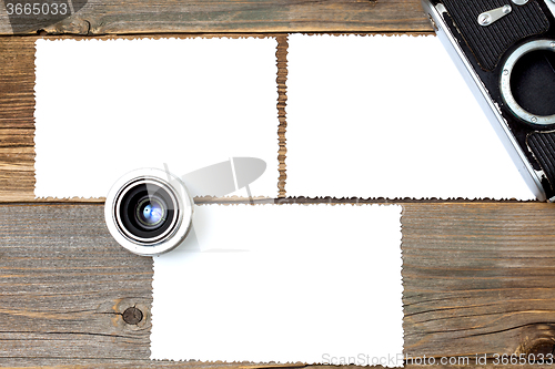 Image of mock up photo, lens and vintage camera on wooden table