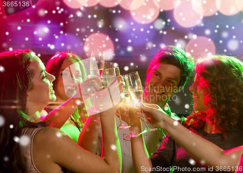 Image of smiling friends with glasses of champagne in club