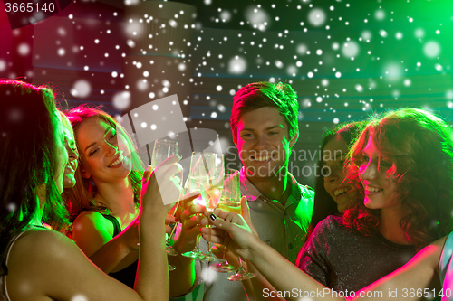 Image of smiling friends with glasses of champagne in club