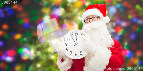 Image of man in costume of santa claus with clock