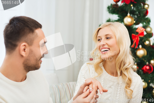 Image of man giving woman engagement ring for christmas