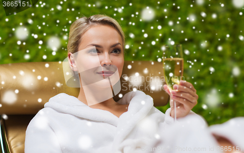 Image of beautiful young woman drinking champagne at spa