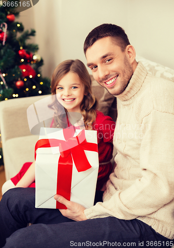 Image of smiling father and daughter holding gift box