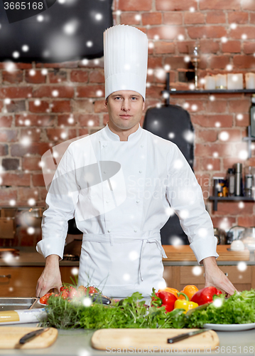 Image of happy male chef cook with vegetables in kitchen