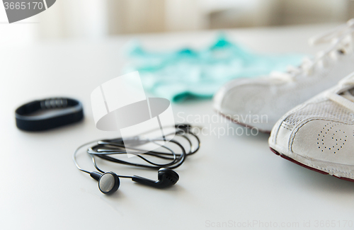 Image of close up of earphones, bracelet and sportswear