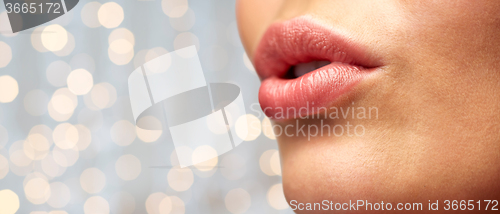 Image of close up of young woman lips over holidays lights