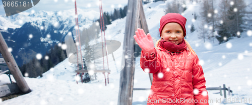 Image of happy girl waving hand over winter background