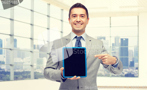 Image of happy businessman in suit showing tablet pc screen