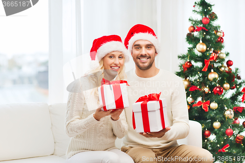 Image of happy couple at home with christmas gift boxes