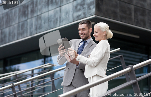 Image of smiling businessmen with tablet pc outdoors