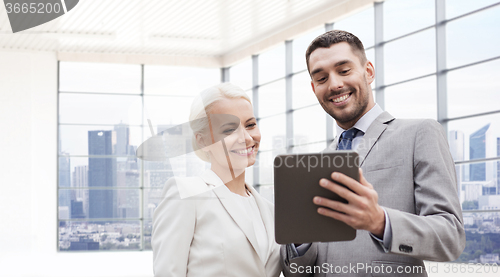 Image of smiling businessmen with tablet pc outdoors