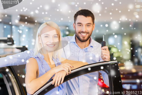 Image of happy couple buying car in auto show or salon