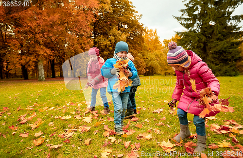 Image of group of children collecting leaves in autumn park