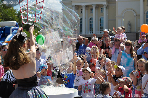 Image of Happy children catch soap bubbles on the street