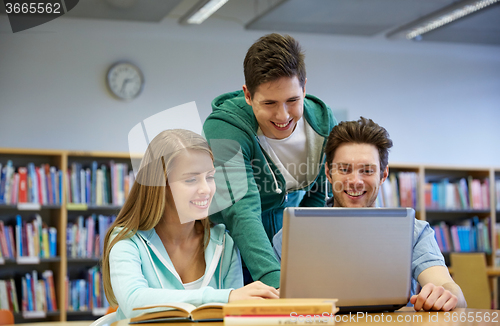 Image of happy students with laptop in library