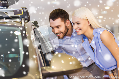 Image of happy couple buying car in auto show or salon