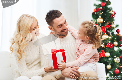 Image of happy family at home with christmas tree