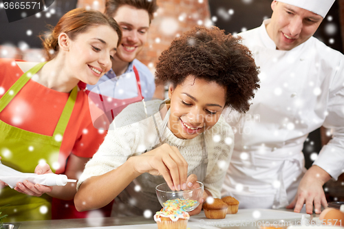 Image of happy friends and chef cook baking in kitchen