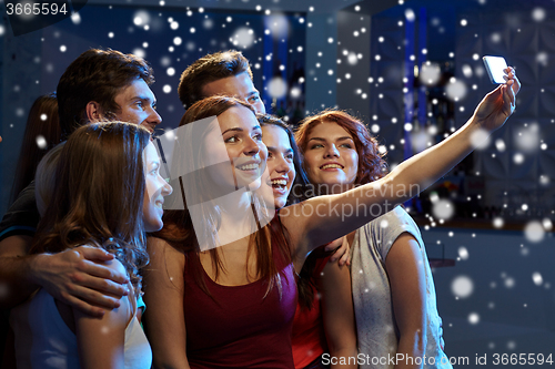 Image of friends with smartphone taking selfie in club