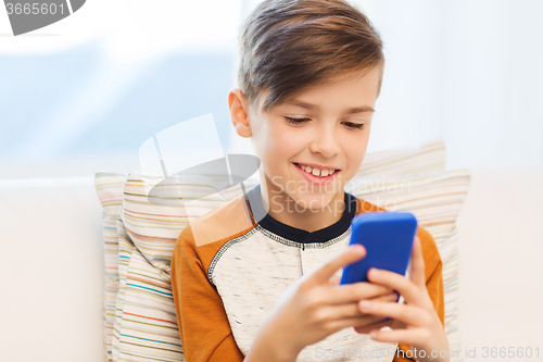 Image of boy with smartphone texting or playing at home