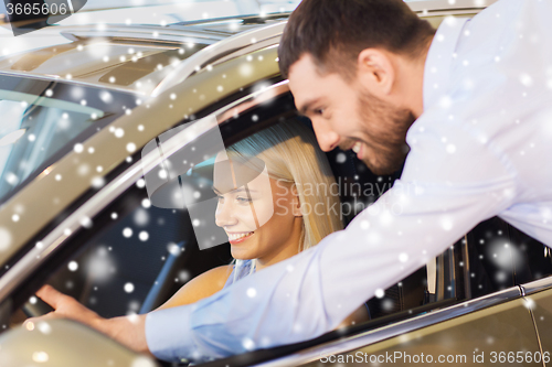 Image of happy couple buying car in auto show or salon