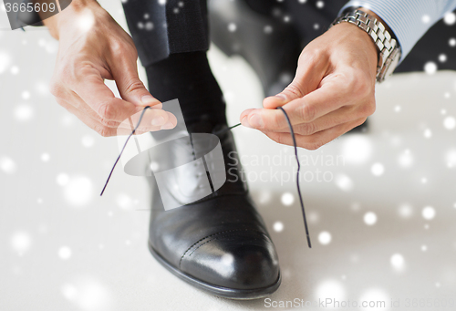 Image of close up of man leg and hands tying shoe lace