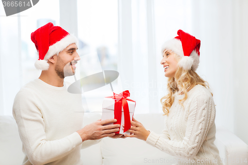 Image of happy couple at home with christmas gift box