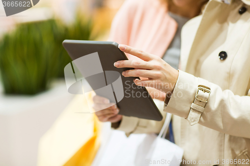 Image of close up of women with tablet pc and shopping bags