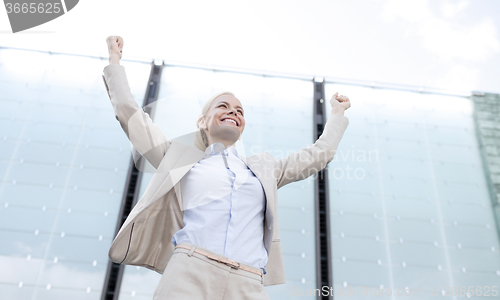Image of young smiling businesswoman over office building