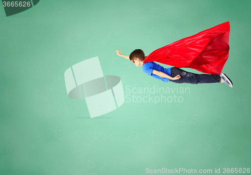 Image of boy in red superhero cape and mask flying on air